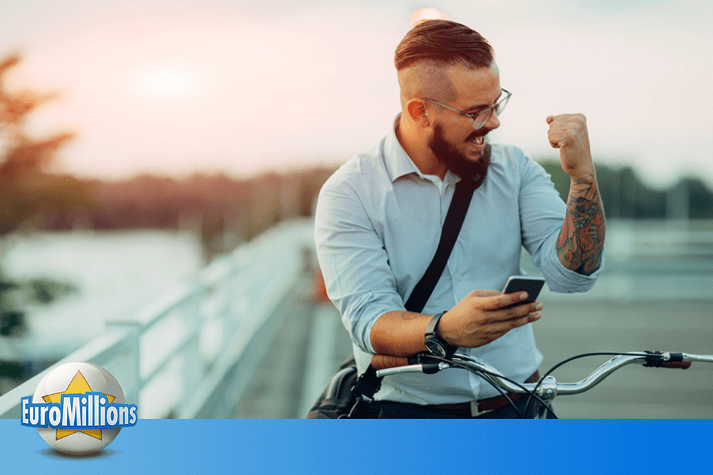 Ein Mann auf einem Fahrrad freut sich über seinen EuroMillions-Gewinn